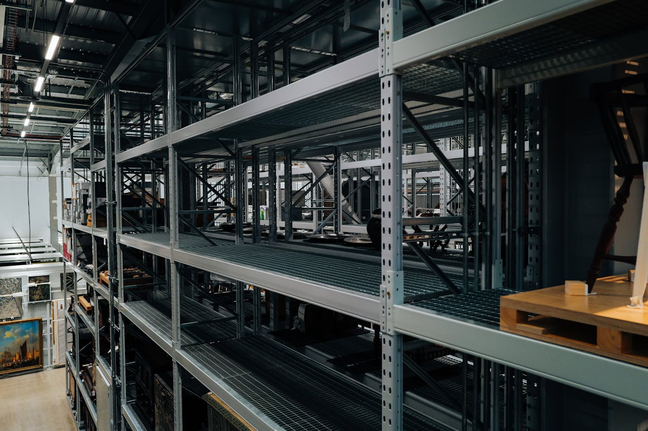 Empty metal storage racks in a spacious industrial warehouse setting.
